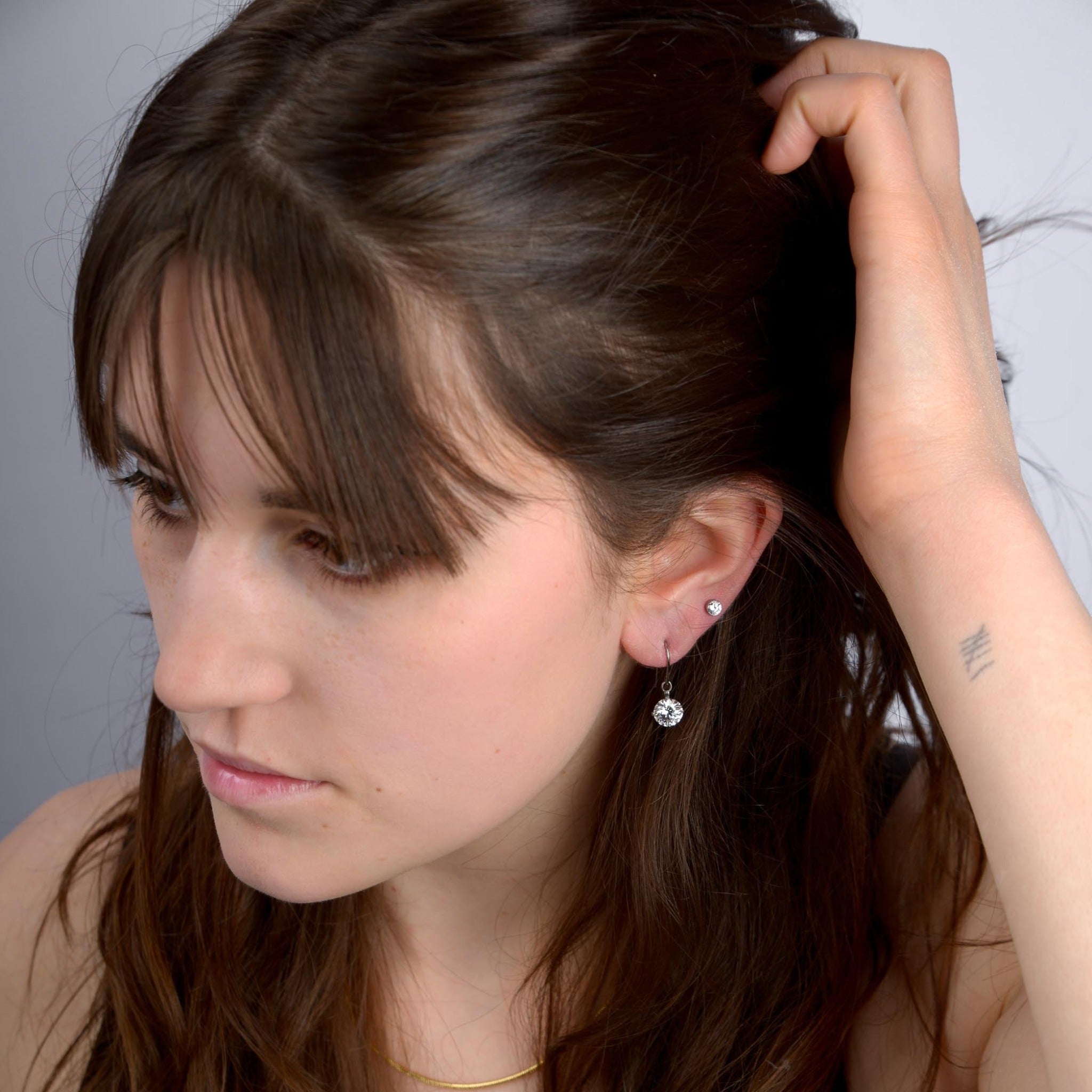 Weibliches Model mit Ohrhänger mit Zirkonia Swarovski® und Ohrstecker aus Titan in Silber von nonu.Berlin - Profilansicht