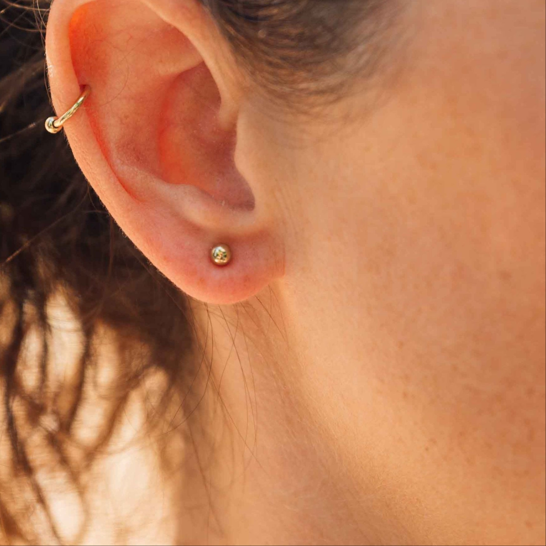 MODEL_MIT_HUFEISEN_UND_TITANOHRSTECKER_KUGEL_IN_GOLD