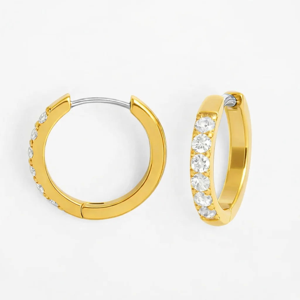 Kleine goldene Titan Huggie-Ohrringe Modell Small mit funkelndem Pavé-Zirkonia-Besatz.