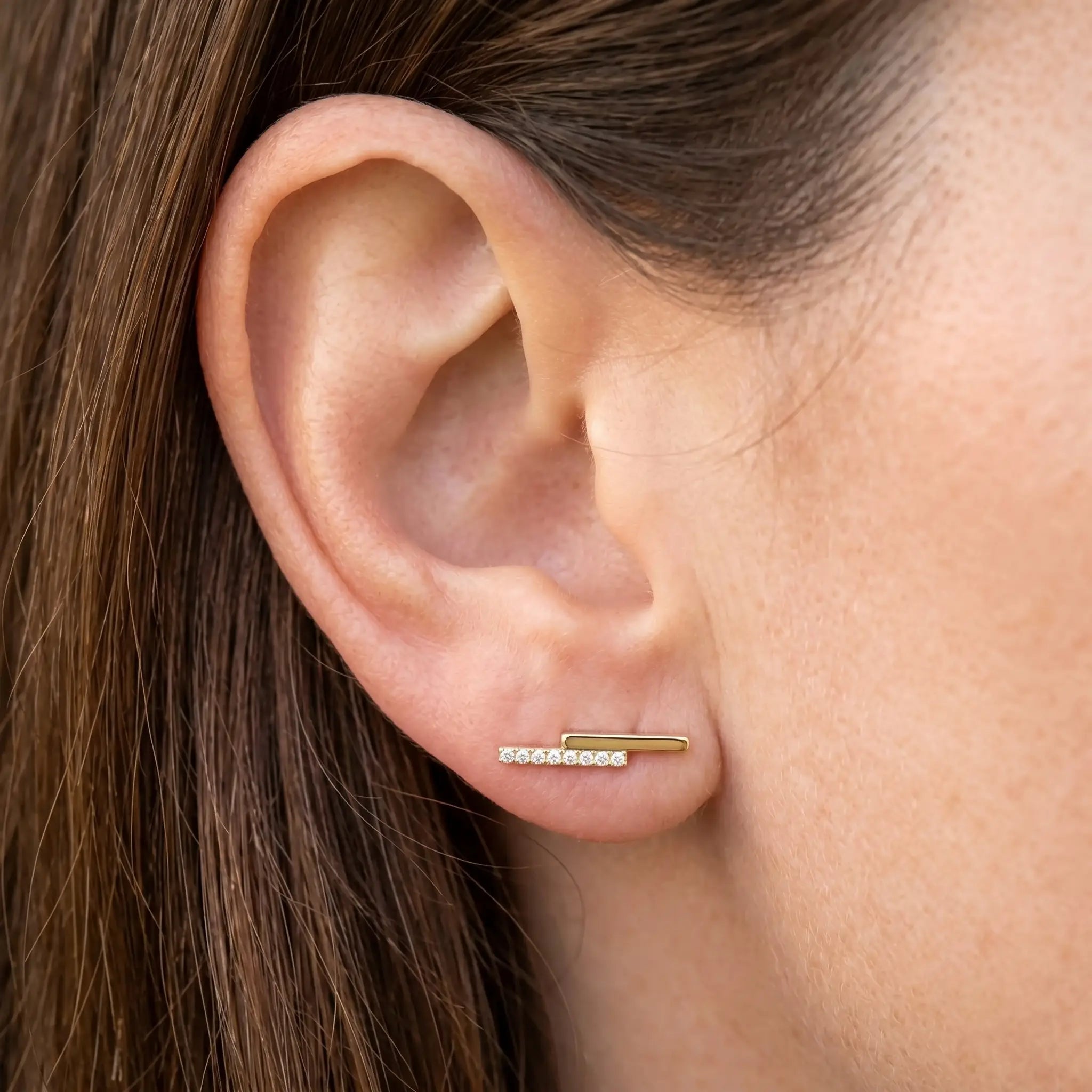 Weibliches Model mit Ohrstecker Linea mit Kristallen aus Titan in Gold von nonu.Berlin - Profilansicht nah