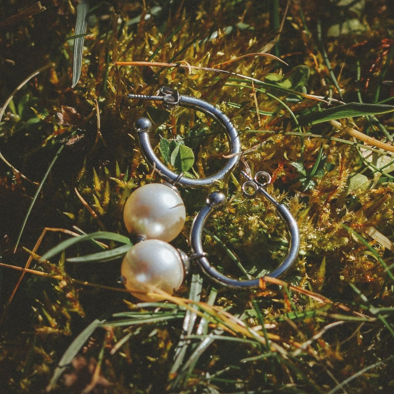 Titan Creolen mit Perlen in Silber von nonu.Berlin in der Natur liegend