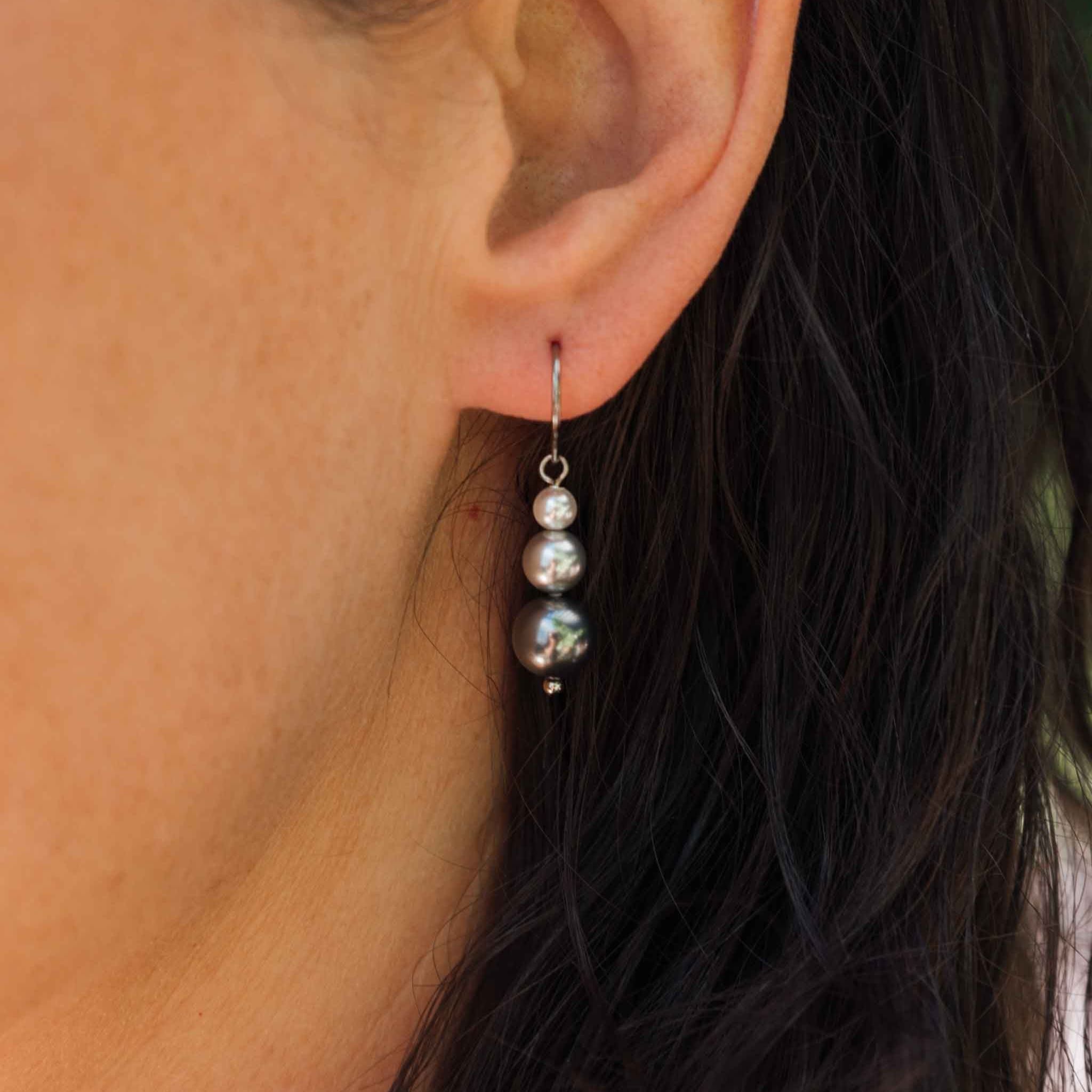 Weibliches Model mit Ohrhänger mit 3 verschieden großen und farbigen Swarovski® Perlen aus Titan in Silber von nonu.Berlin - Profilansicht